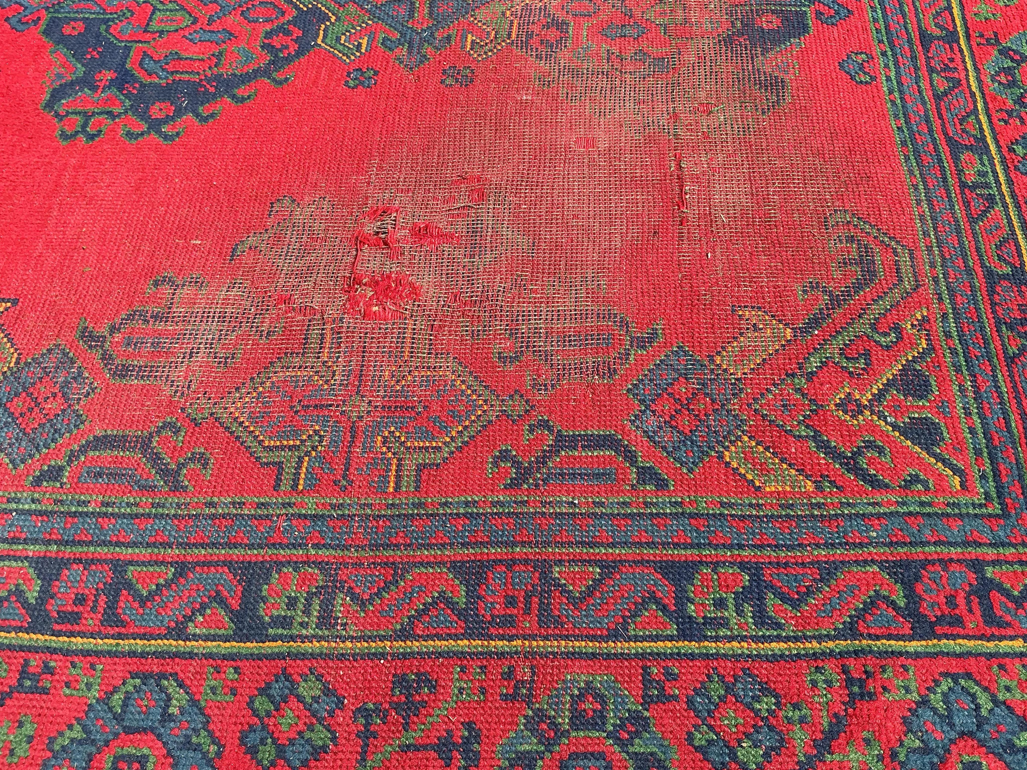 An early 20th century Afghan red ground carpet, 445 x 375cm